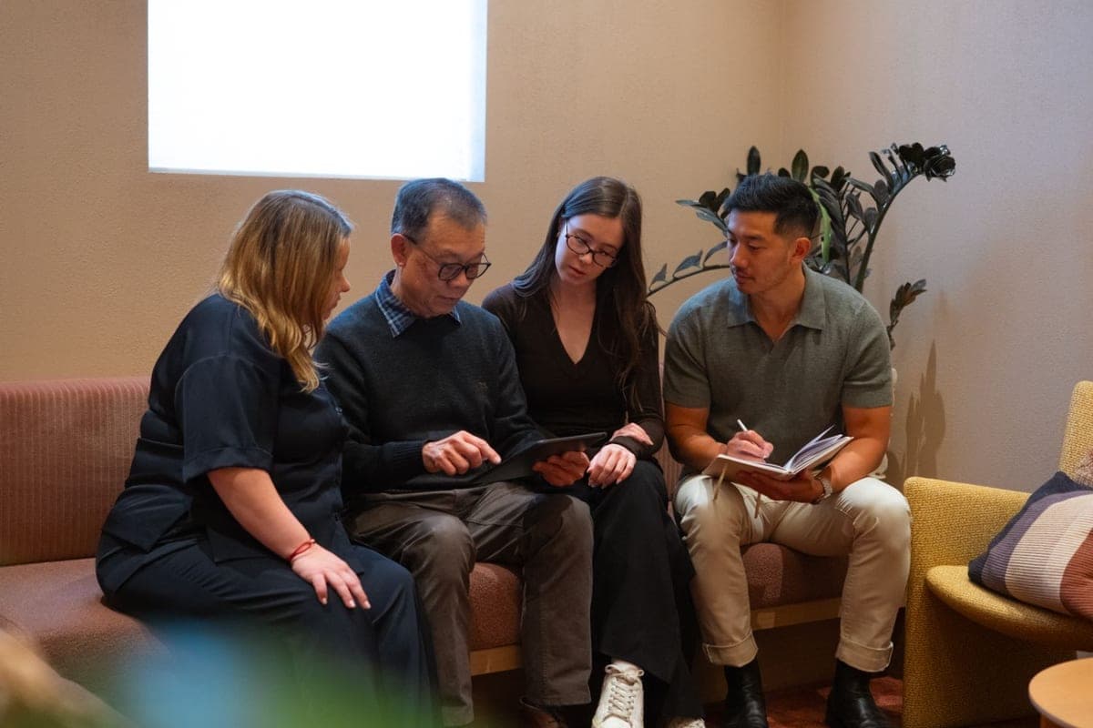 The four Pair co-founders sitting together, reviewing work on a tablet and notebook